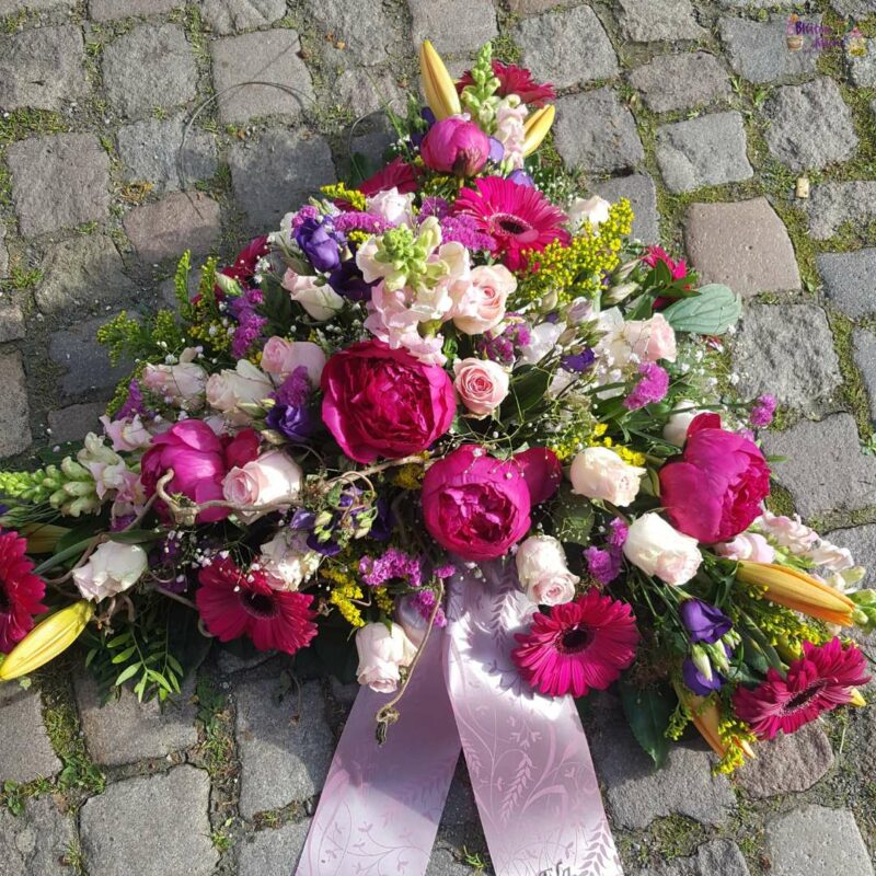 Trauergesteck - Olbernhau Blumenladen Blütenküche - Produktfoto eines flachgesteckten dreieckigen Grabgestecks in Pink