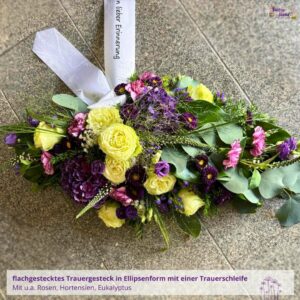 Trauergesteck - Blumenladen Olbernhau Blütenküche - Produktfoto eines Trauergestecks zur Beerdigung in Ellipsenform in Weiß-Lila, Draufsicht