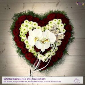 Trauergesteck Herz - Blumenladen Olbernhau Blütenküche - Foto eines gefüllten Trauergestecks in Herzform mit Rosen, Chrysanthemen und Orchideenblüten, liegend auf einem Holzhintergrund fotografiert
