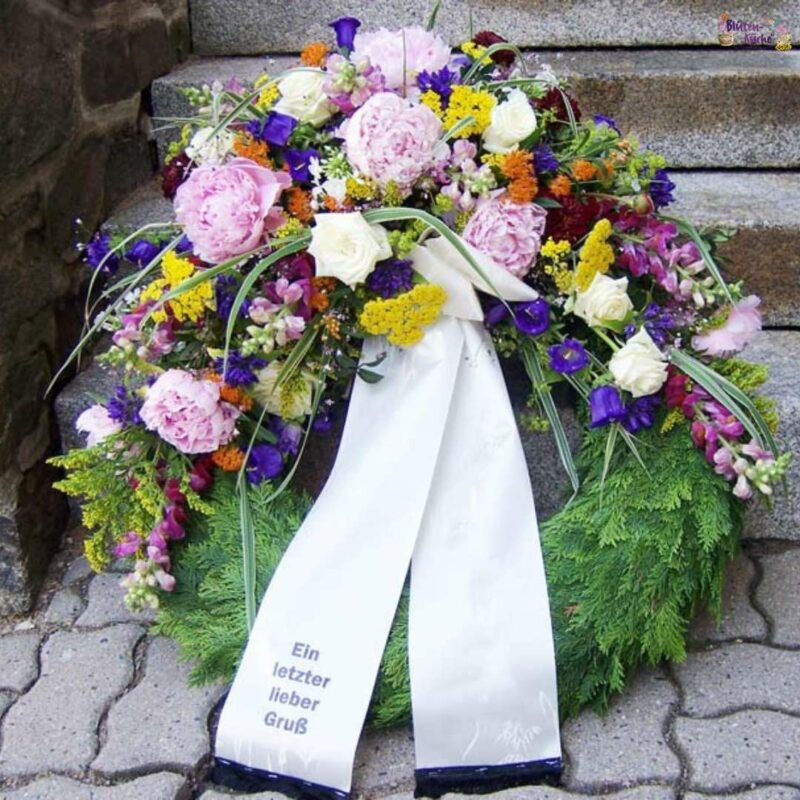 Trauerkranz - Blumenladen Olbernhau - Foto Trauerkranz mit kleinem Blumengesteck an Treppe gelehnt